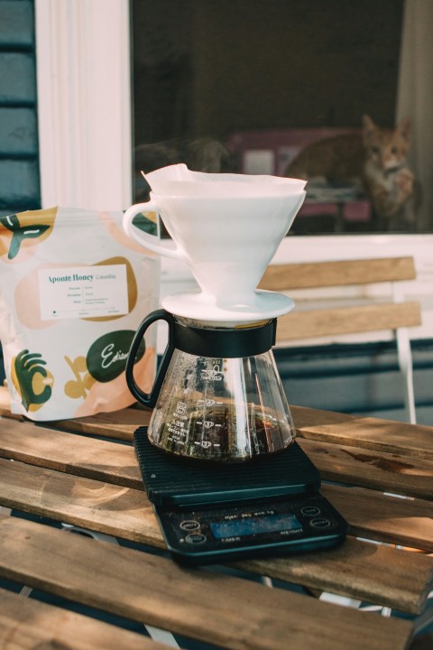 white ceramic teacup on black coffee maker