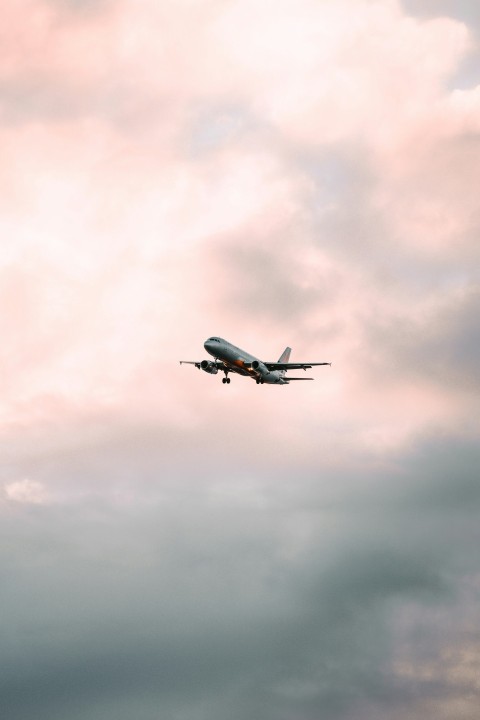 white airplane in mid air during daytime