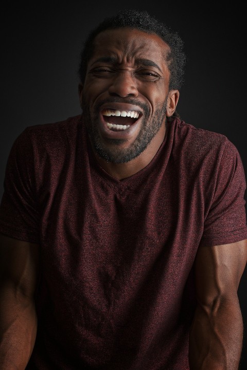 smiling man wearing brown t shirt