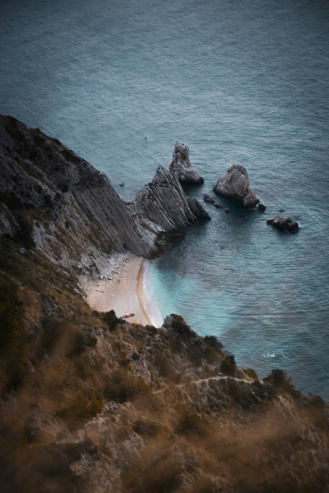 a rocky cliff with a body of water below _epsk8B