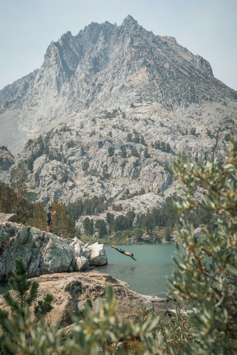 person standing on rock near body of water during daytime