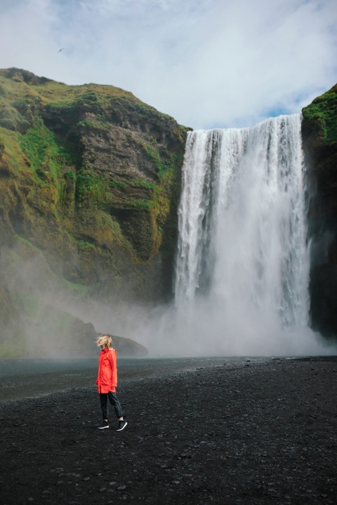 a man standing in front of a waterfall