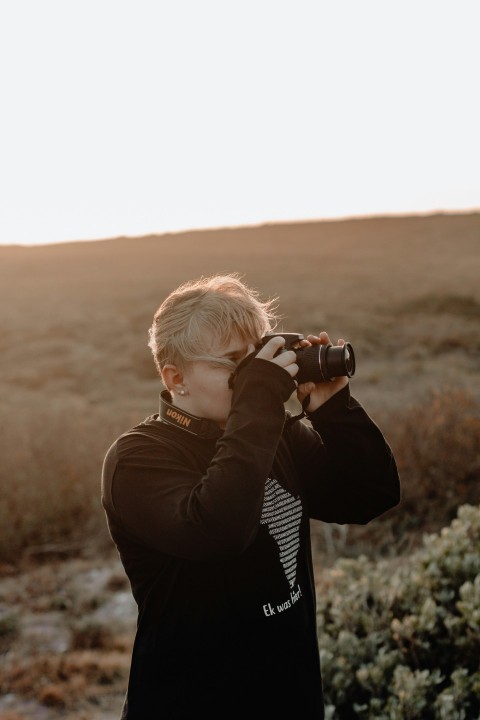 man wearing black jacket standing while taking photo