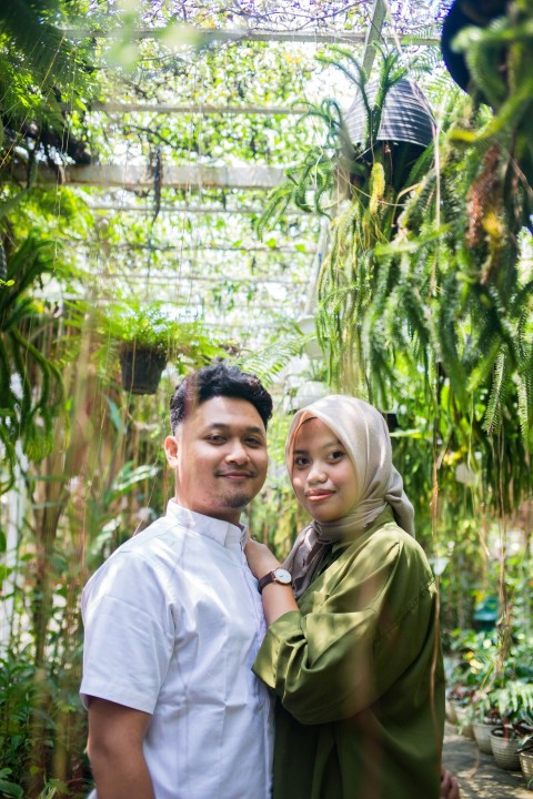 a man and woman standing in a greenhouse