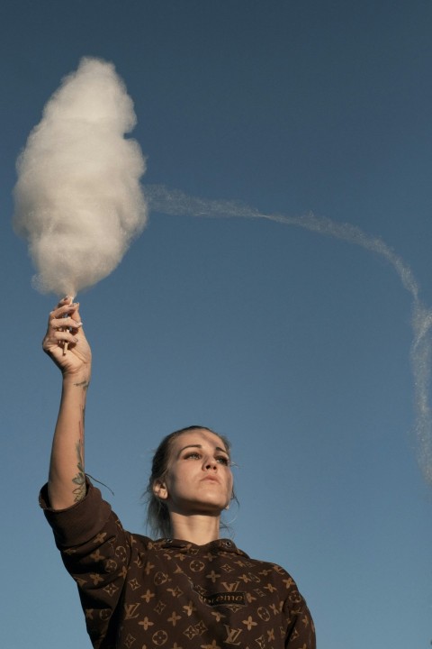 woman in black shirt holding white cotton candy