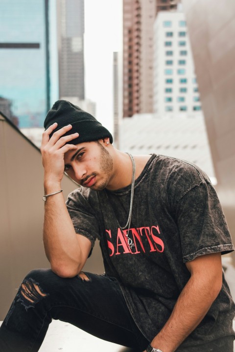 man in black and white crew neck t shirt and black cap