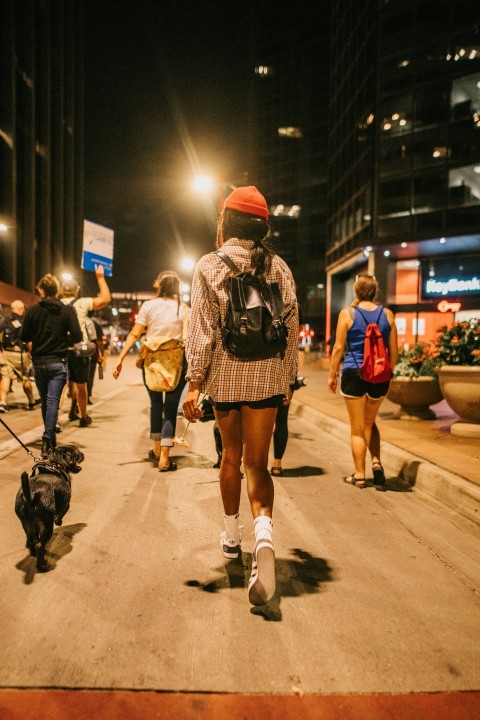 a group of people walking down a street at night