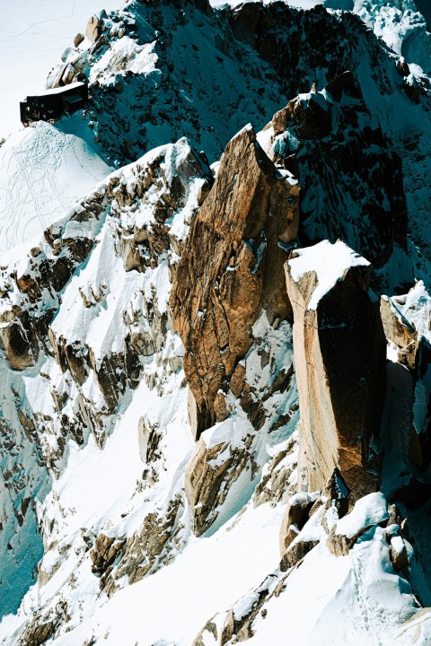 a snow covered mountain with a snowboarder on it