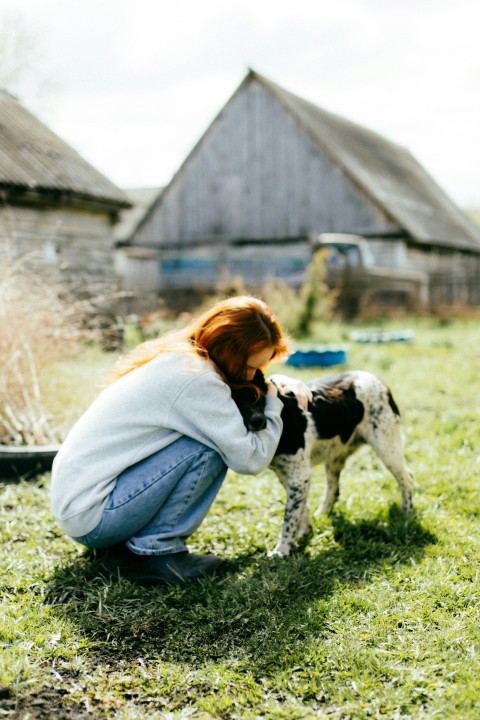 a woman kneeling down next to a dog