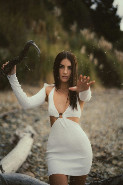 a woman in a white dress holding a snake