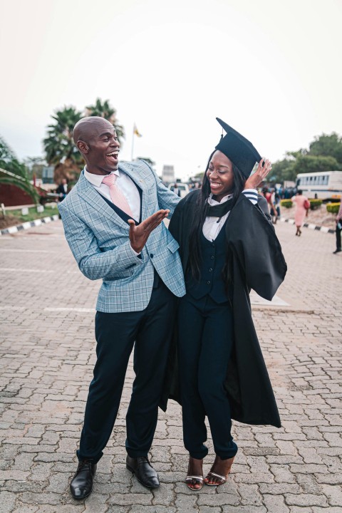 man in black academic gown beside man in blue and white plaid button up shirt bFwilbDw