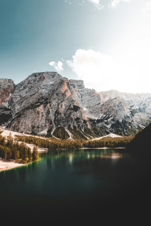 lake near mountain under blue sky during daytime