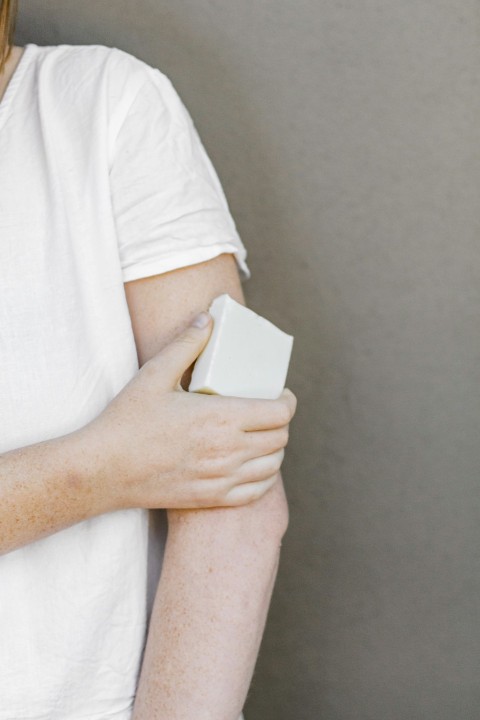 person in white t shirt holding white box