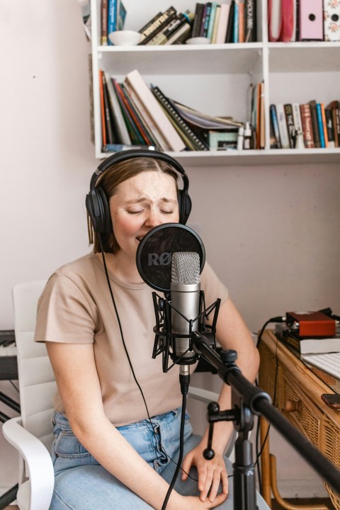 woman in white t shirt standing beside microphone