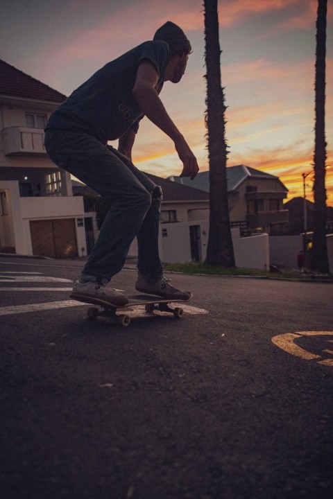 man in black t shirt and blue denim jeans riding skateboard during daytime B