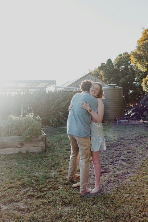 man in blue t shirt hugging woman in green t shirt