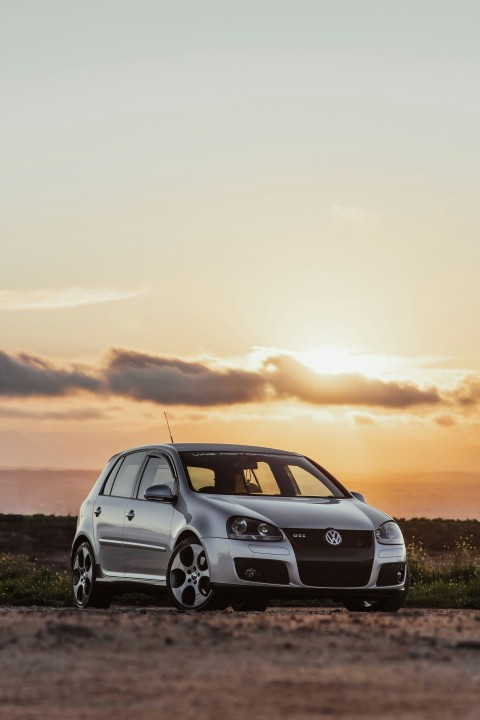 white bmw x series on green grass field during sunset