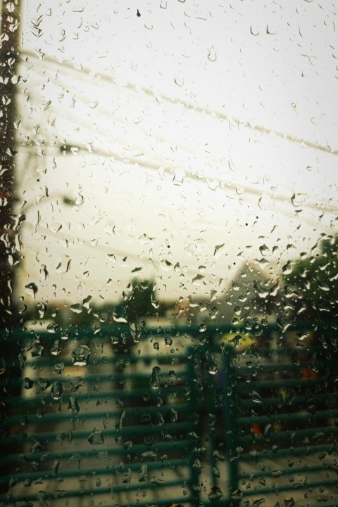 a view of a building through a rain covered window