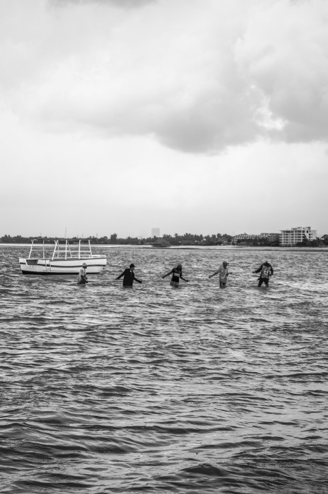 a black and white photo of a group of people in the water