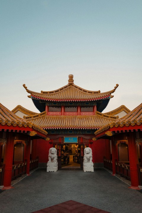 a chinese building with statues in front of it