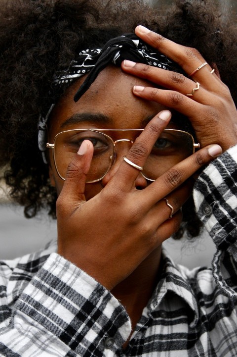 woman in white and black plaid shirt wearing gold framed eyeglasses