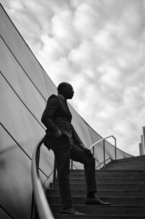 man in black jacket and black pants walking on stairs OMqh