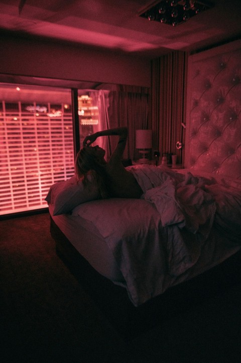 a person laying on a bed in a dark room