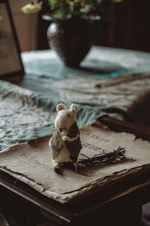 a teddy bear sitting on top of a book on a table