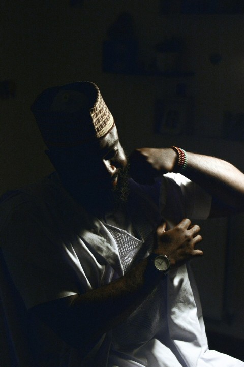 a man sitting in a chair with his arm around his neck