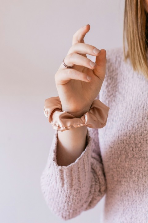 woman in white knit sweater holding her hand