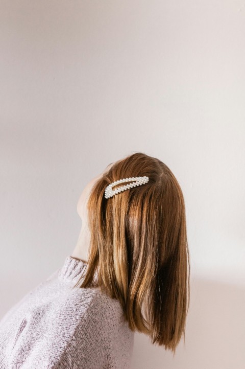 woman in white shirt with brown hair tied