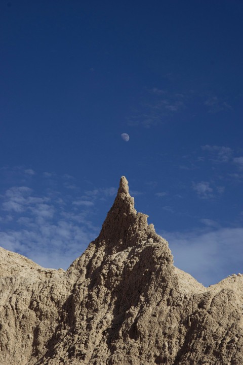 a very tall mountain with a moon in the sky