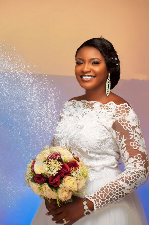 woman in white long sleeve dress holding bouquet of flowers