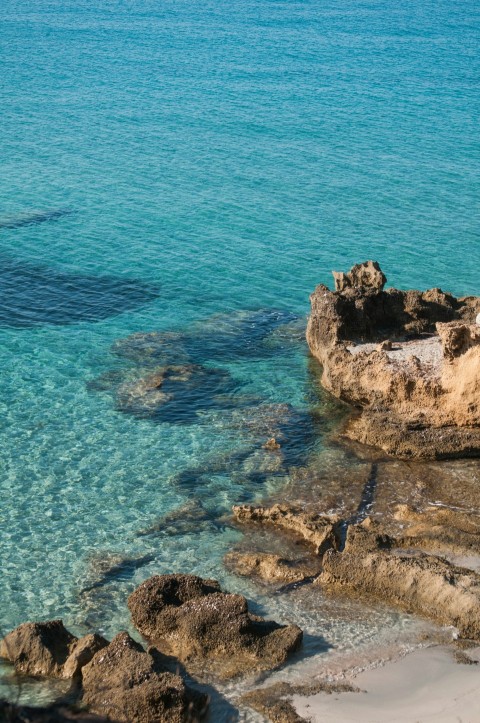 brown rock formation on blue sea during daytime Wqv