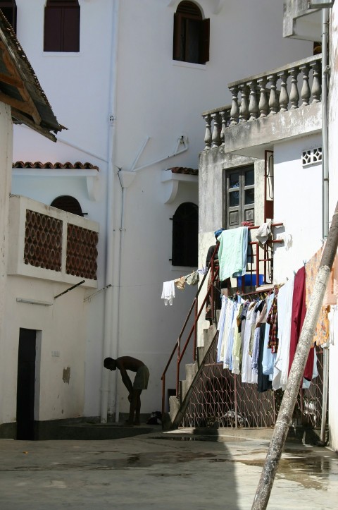 clothes hanged on clothes line near white concrete building during daytime