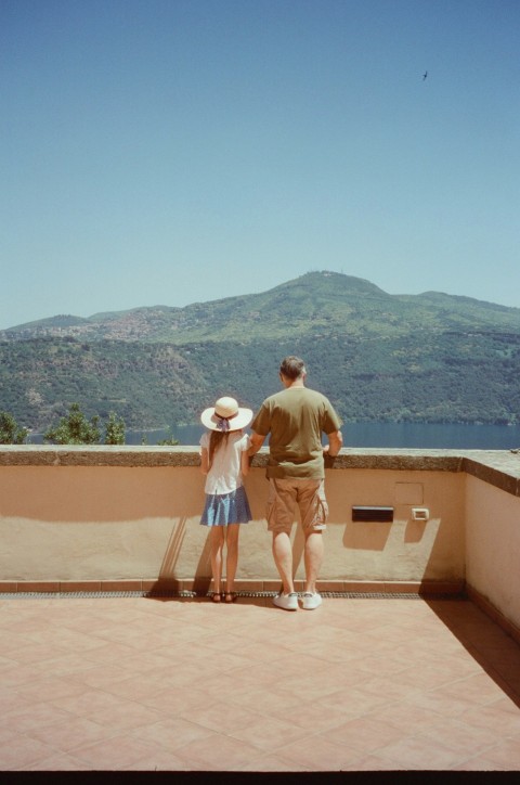 a man and a little girl standing on a balcony