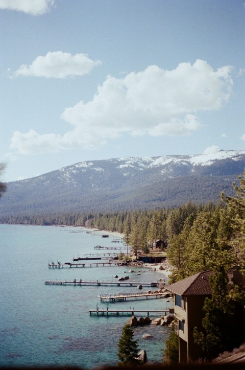 a body of water surrounded by trees and snow covered mountains