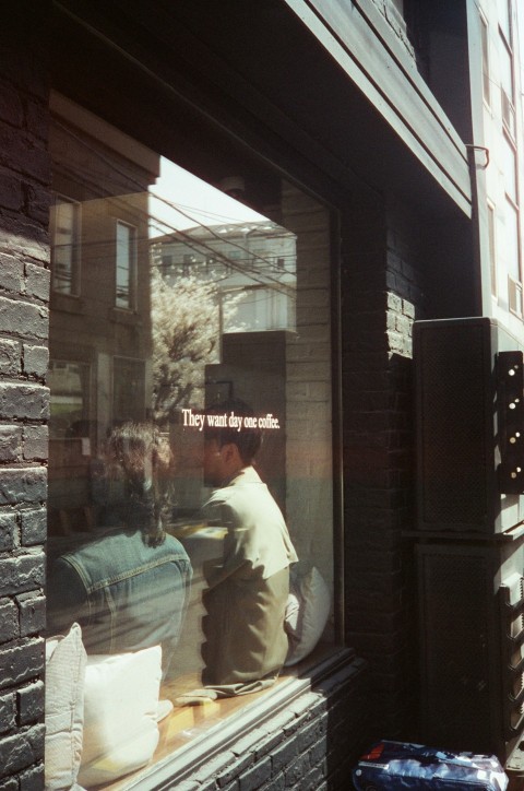 a man sitting on a bench looking out a window