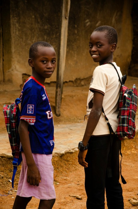 boy in white and blue polo shirt standing beside boy in blue and red polo shirt