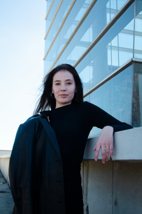 a woman leaning against a wall in front of a building