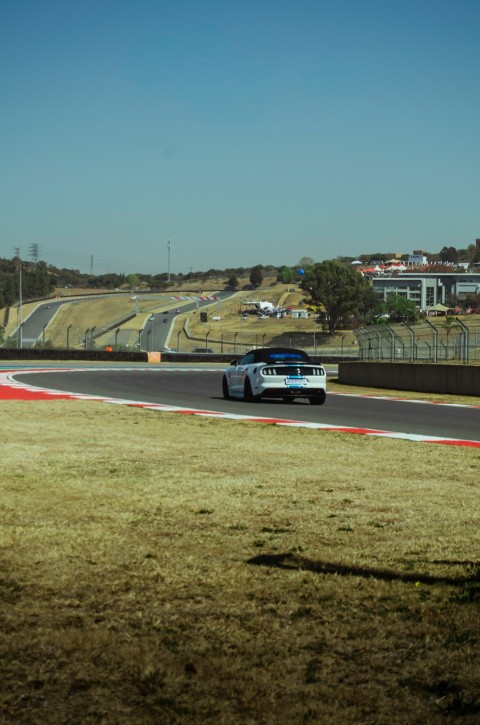 a white car driving down a race track