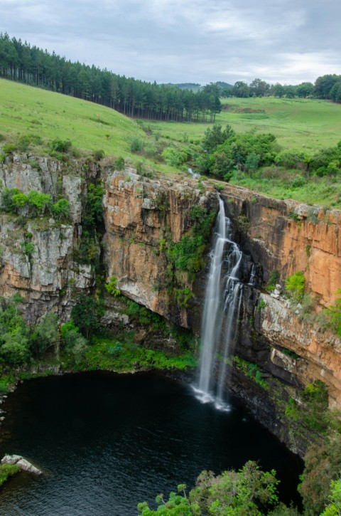 waterfalls on brown rocky mountain during daytime