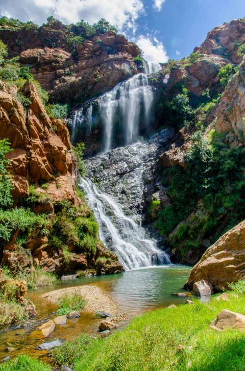 water falls between brown rocks