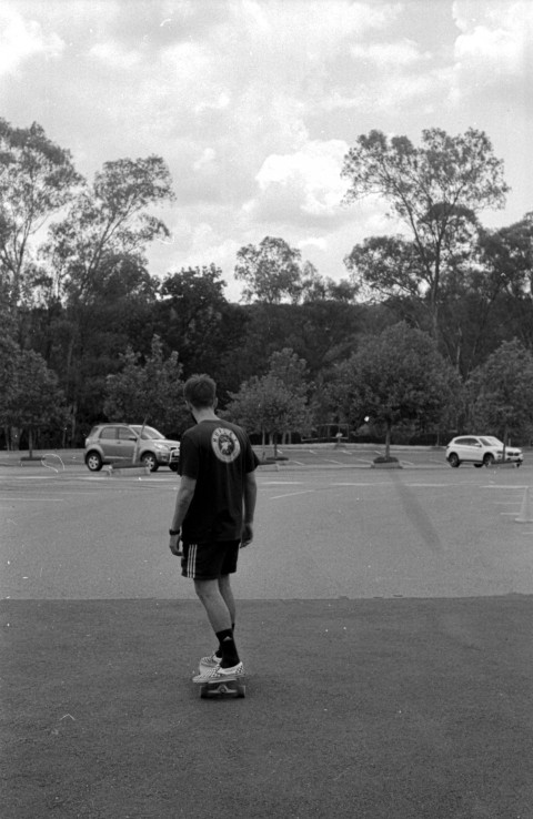 a young man riding a skateboard up the side of a road