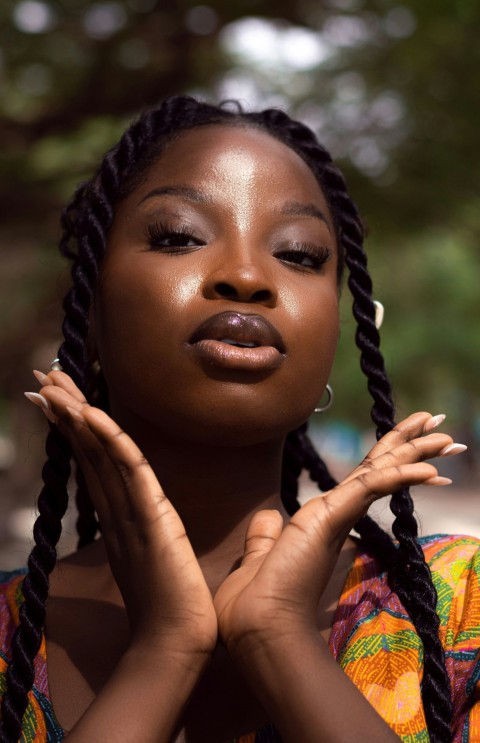 a woman with braids holding her hands together