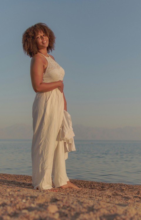 a person in a dress standing on a beach