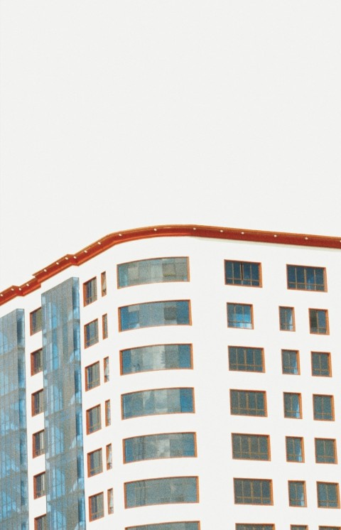 an airplane flying in the sky over a building