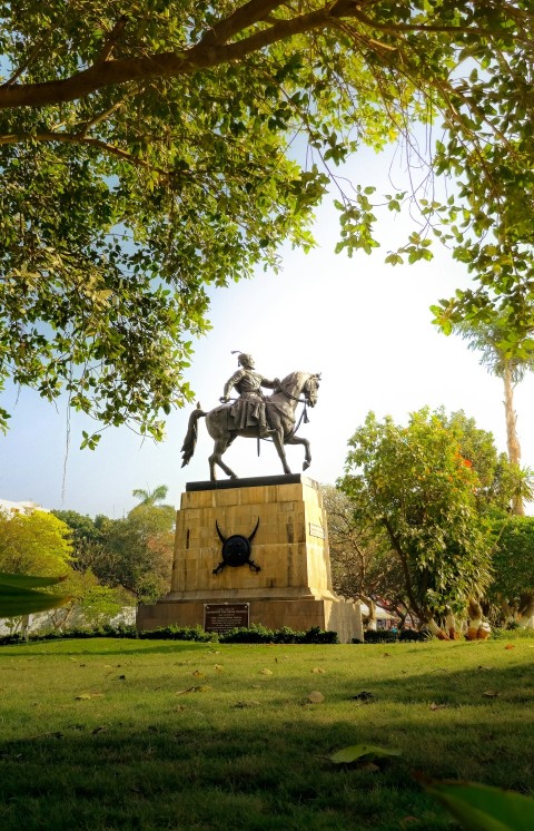 a statue of a man riding a horse in a park