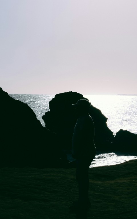 a person standing on a beach next to the ocean