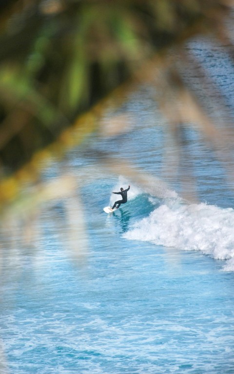 person riding surfboard in ocean